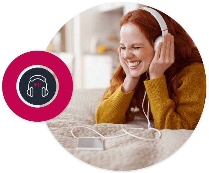 Picture in a circle of a ginger girl lying on a bed. She is holding her headphone because she is listening music from her phone.